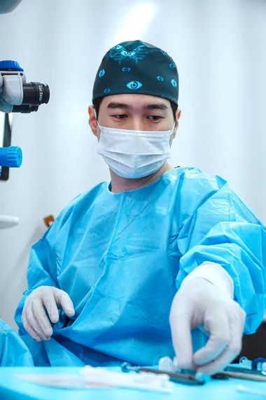 Dr. Hugo Araki em pé no consultório, de jaleco